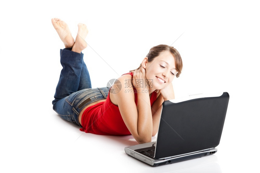 无线的闲暇坐在地板上工作着笔记本电脑的美丽和快乐年轻女子坦率图片