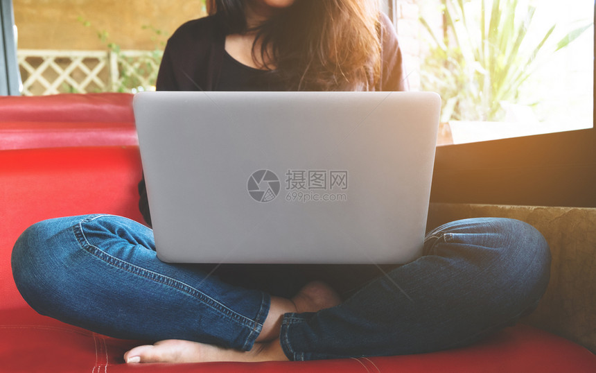浏览坐着网络在咖啡馆使用笔记本电脑的年轻妇女图片