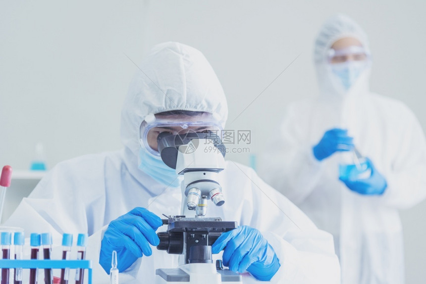 在实验室使用显微镜进行研究的男科学家图片
