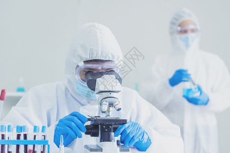 在实验室使用显微镜进行研究的男科学家图片