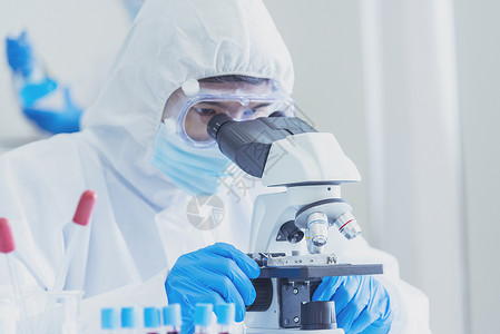 男科学家在实验室使用显微镜进行疫苗研究背景图片