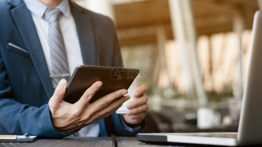 经济学家在咖啡店厅从事数字平板电脑和笔记本与金融业务战略的商人消息触碰图片