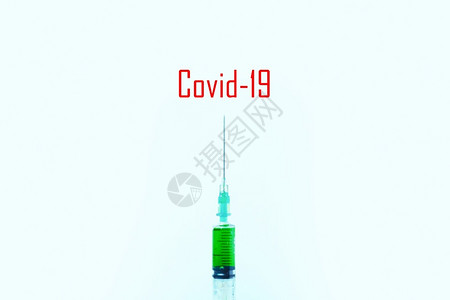 实验室小样蓝底注射针筒中的绿色液体Covid19l注射的概念图片