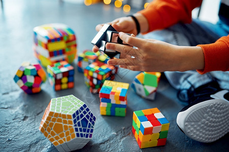 合乎逻辑的男孩试图解决不同的谜题立方体玩具用于大脑和逻辑心智培训创造游戏解决复杂的问题男孩试图解决不同的谜题立方体男孩试图解决不同的谜题立背景