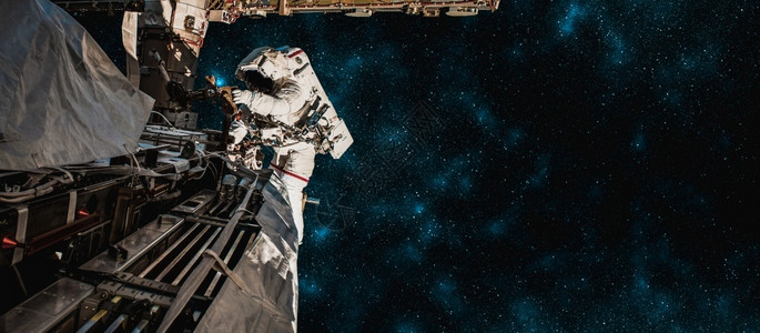 尽管宇航服员太空人在为外层间的站工作时进行太空走宇航员穿着全套太空服进行操作土制的背景图片