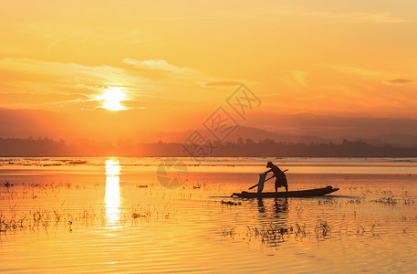 农民贫穷的环境在自然湖中日出时在自然湖中的木船上渔民轮椅图片