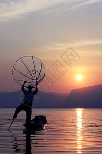 桨户外平衡湖边一个渔民的轮廓图片