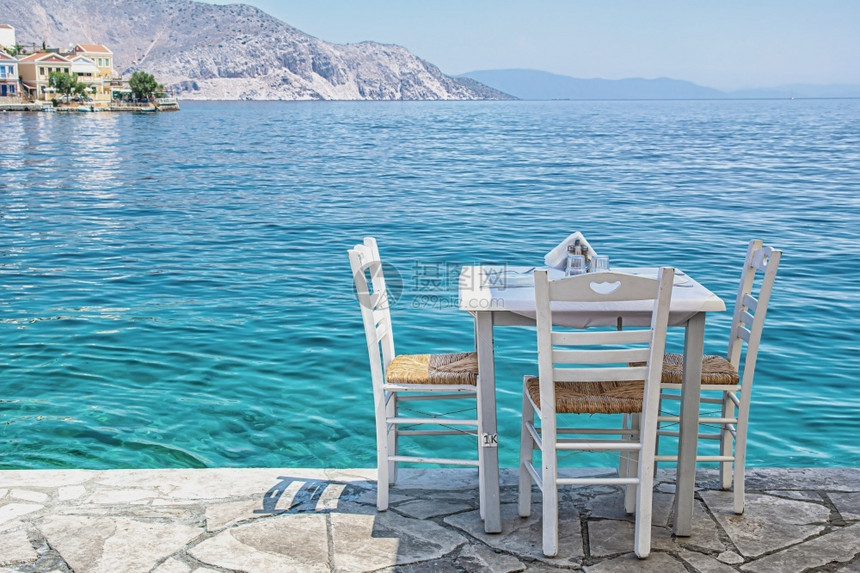 西米镇海边典型的希腊小酒馆里带桌子的白色椅西米镇海边典型的希腊小酒馆里带桌子的椅白色帆酒吧图片