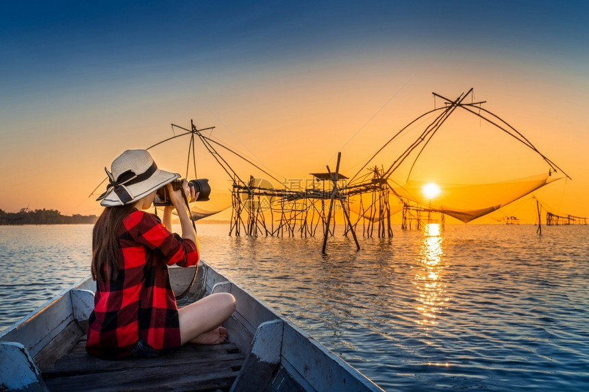 轮廓夏天女旅行者在泰国Phatthalung的Pakpra给渔网拍照早晨图片