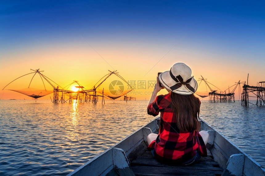 女旅行者在泰国Phatthalung的Pakpra给渔网拍照天空美丽的日落图片
