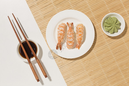 海鲜餐厅广告牌寿司日概念配有芥末筷子饭团生鱼片手背景