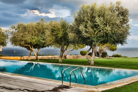 椅子景观游泳池以树木和海洋为一景屋图片