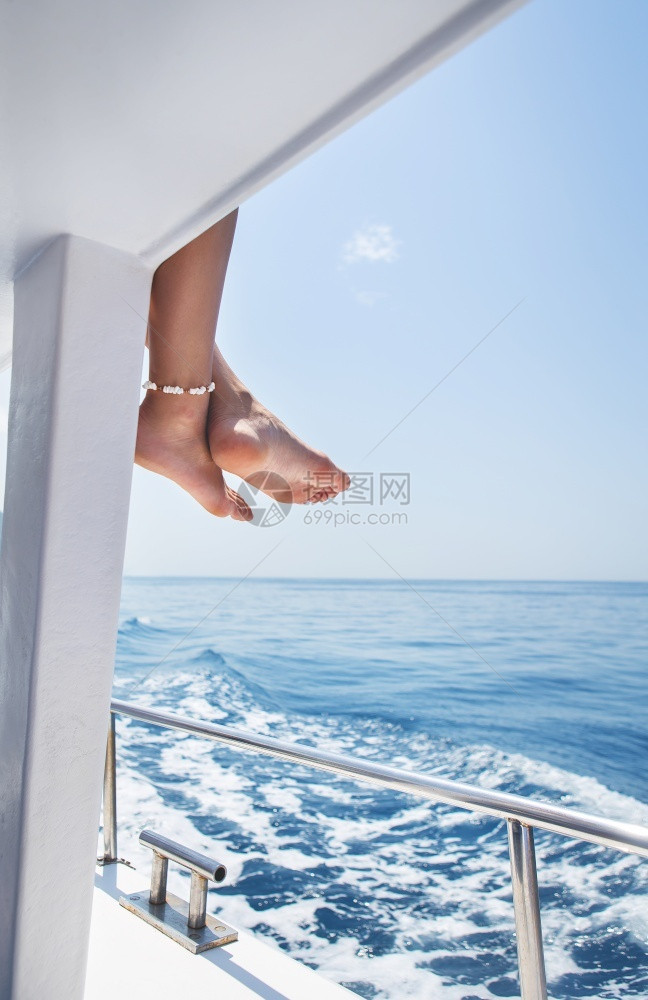 快乐的夏天幸福美丽女腿特写镜头与手镯贝壳在游艇上航行暑假快乐和享受的概念形象假期海洋和休息美丽的女腿特写镜头与手镯贝壳游艇海洋和图片