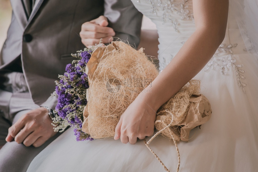 新娘在婚礼仪式上拿着一束花的鲜手艺术女图片