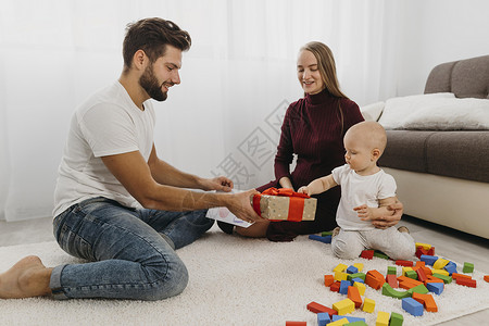 快乐父母给孩子送礼物的家庭婴儿沙发图片