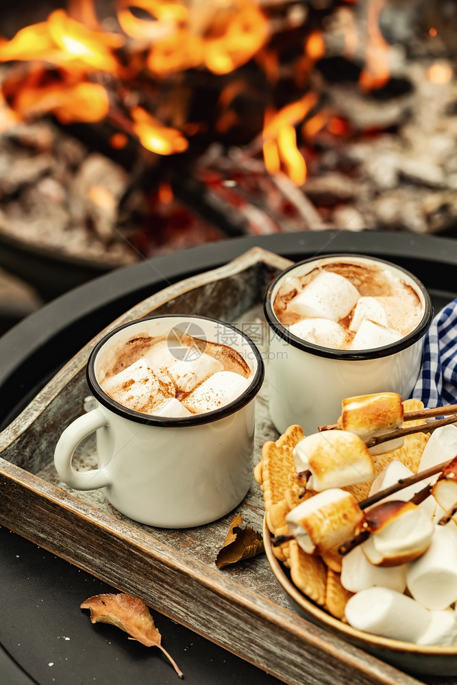 喝两杯咖啡可或热巧克力和烤棉花糖的切片在营火期间使用秋季节假日户外招待食物或者图片