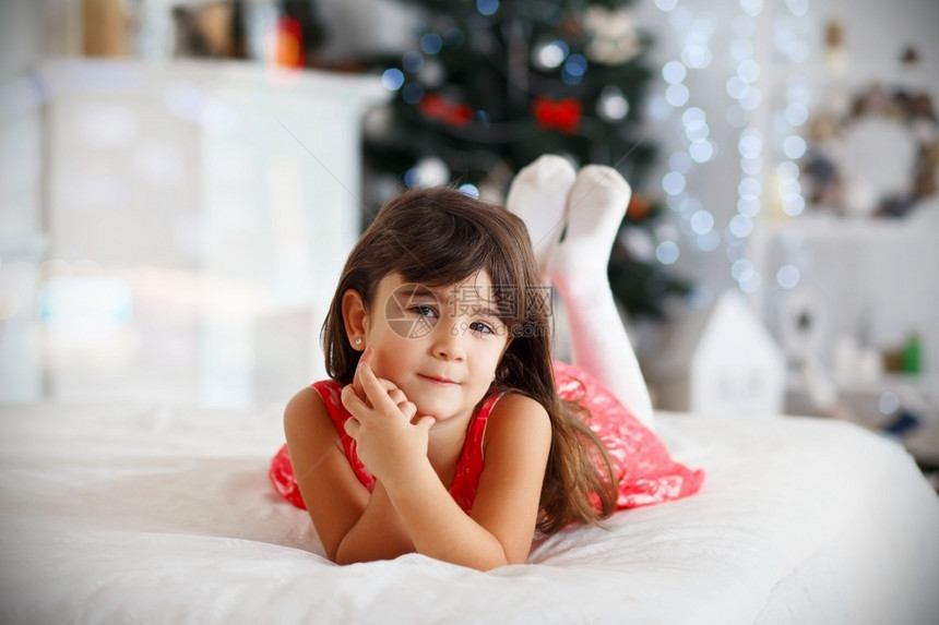 美丽的小女孩在圣诞装饰中等待奇迹的美丽小姑娘屋树微笑图片