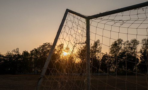 玩镜片在公共体育场中足球目标在日落时光背景下复古的图片