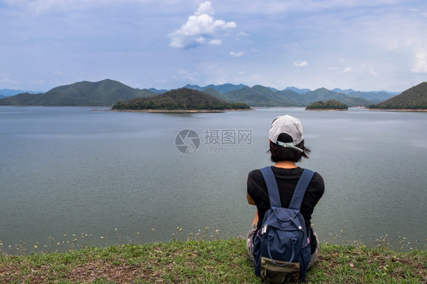 成人女孩片刻在湖岸的边坐在和享受美好景色平时刻的年轻青女背影其景为假日旅行概念休息和享受生活方式选择重点等山脉分布在上图片