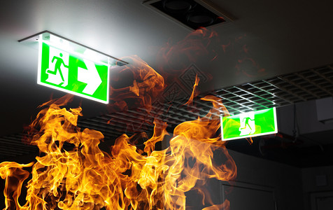 天花板火抽烟地面夜间办公室的天花板上挂着热火和绿色逃生标志防训练和疏散准备的概念方向设计图片