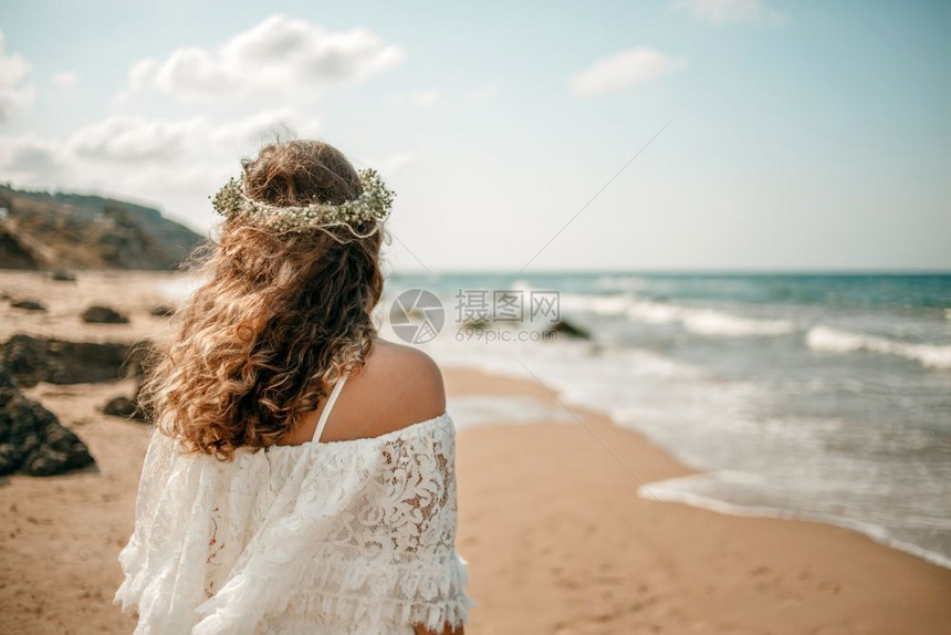 在海滩上穿着白色婚纱的新娘头部从背面看到一朵花圈庆典白色的女图片