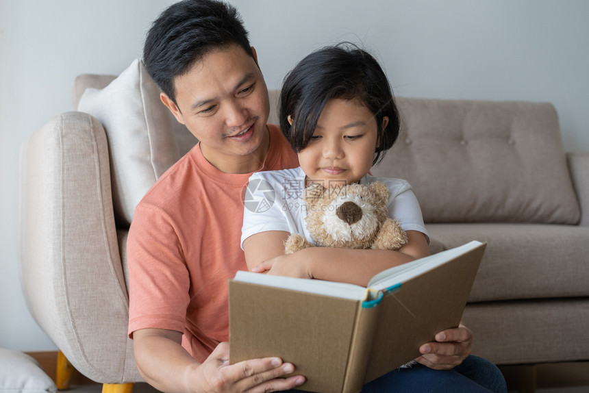 地面愉快父亲身份亚洲和女儿在家中的地板上阅读书籍自学概念亚洲父女图片