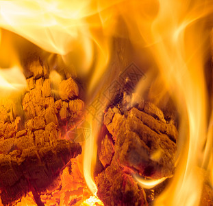 篝火黑色的燃烧在壁炉里火和柴紧贴在壁炉里烧柴的镜头附近图片