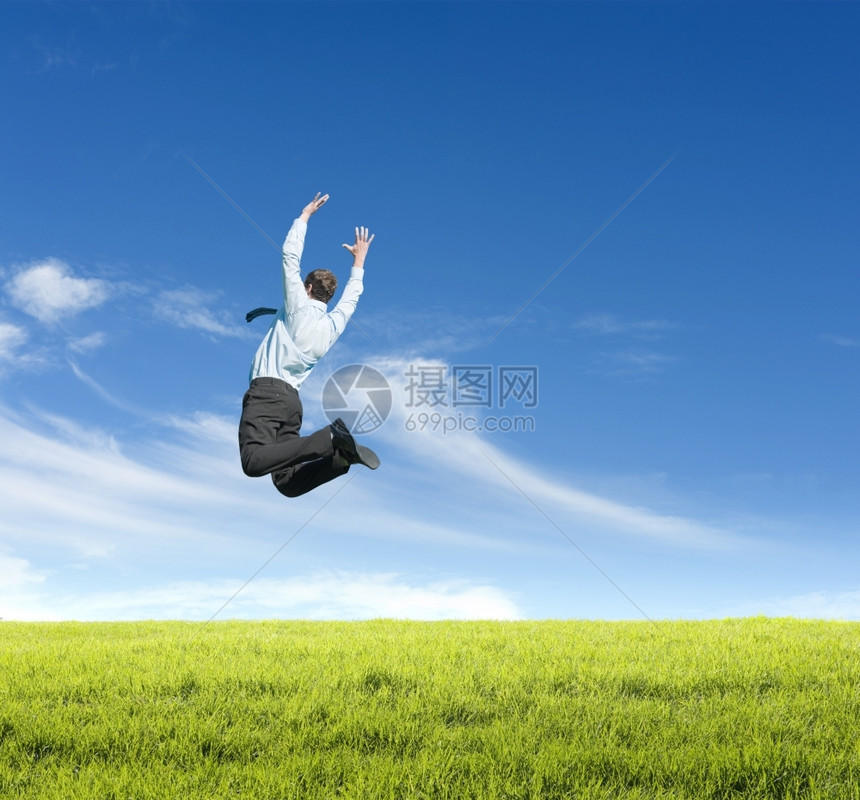 生态蓝色的男快乐年轻人在晴天背景下草地上跳跃图片