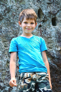 青年轻的微笑男孩站在陡峭岩石附近孩子图片