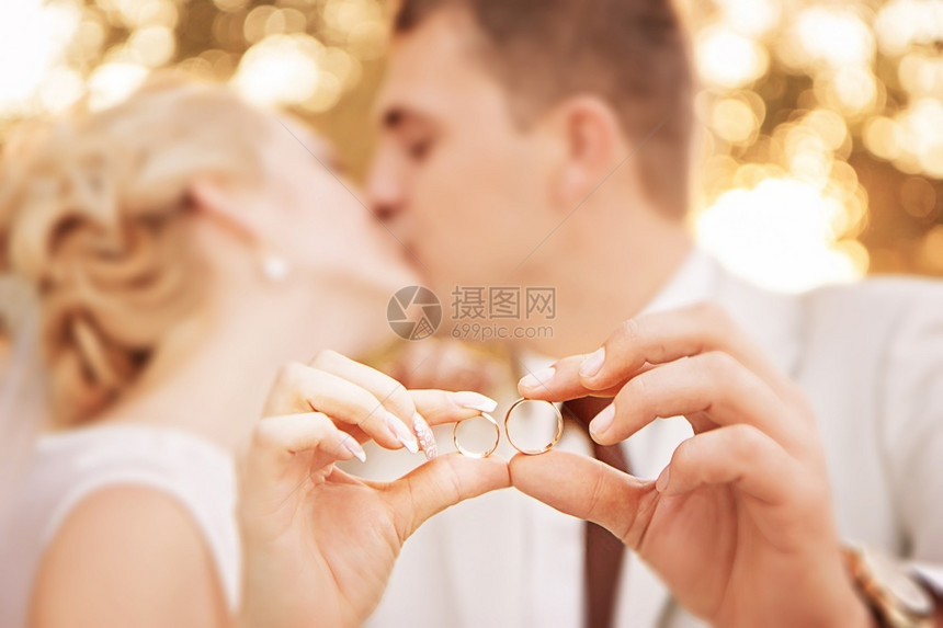 新婚夫妇展示两枚金戒指图片