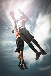 大满贯男生空气两个篮球运动员在街头打篮子一起跳来接球去追背景