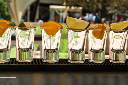 派对与准备喝龙舌兰酒的橙子和利梅切片线上的小透明玻璃酒吧鸡尾图片