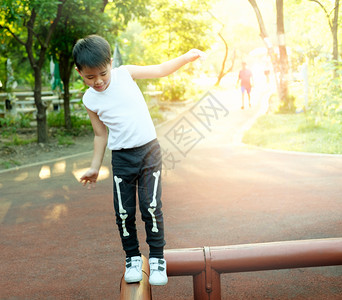 健康伸出的在公园中平衡木材的亚洲男孩稳定图片