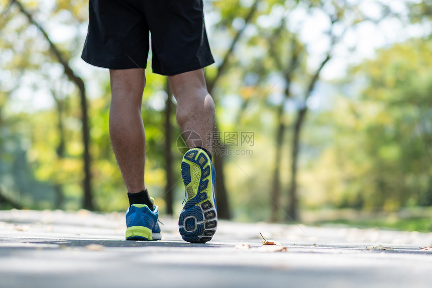 拉伸鞋温暖的年轻健身男子腿在户外公园散步男跑者在外面的路上跑步亚洲运动员在阳光下人行道上慢跑和锻炼运动健康和概念图片