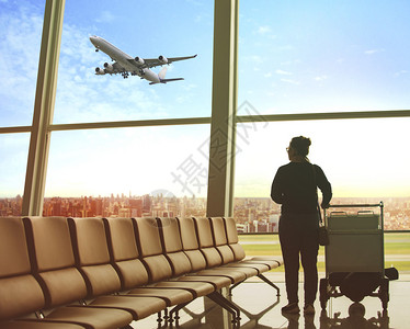 坐在机场终点站和客的单身妇女乘飞机到户外旅行主题等待查看窗户图片