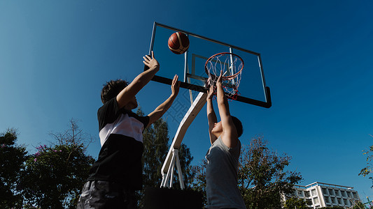 体育和娱乐概念青年男少放学后在法院打球篮的年青男子专业播放器努力图片