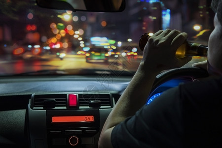 醉人心脾夜景路醉人晚上在城里开车时喝啤酒左手驾驶系统很危险左手驾驶系统城市背景