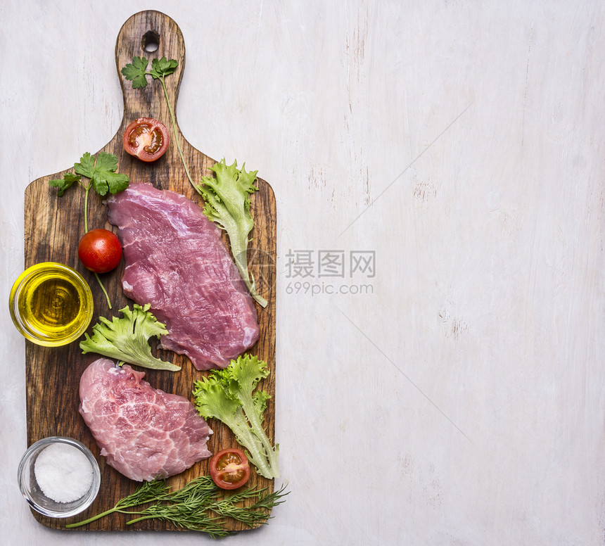 乡村用蔬菜和草药肉刀叉子的猪排配有油料和调味品的切菜板上边界木制生锈背景文字位置百里香调味料图片