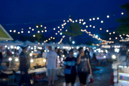 由人们为背景使用在夜间行走的市场外举行闪亮节活动集市展示食物街道图片
