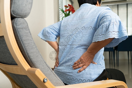 男人患病的疼痛老年妇女在家背痛健康问题概念图片