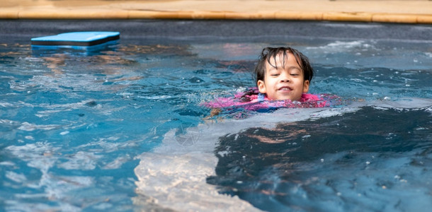 小女孩在夏日游泳池里玩耍背景图片