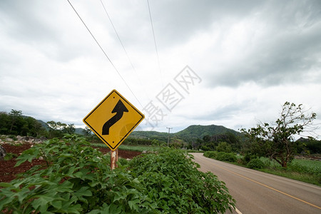 黄色的坡度下交通标志警告在背景绿草上行驶时不要绕过路面图片