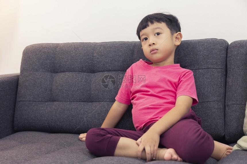 童年微笑的小男孩看电视按遥控器在客厅舒适沙发上拉着遥控器在数字智能电视上玩游戏愉快乐的小孩使用最喜爱的乐子数字年轻图片