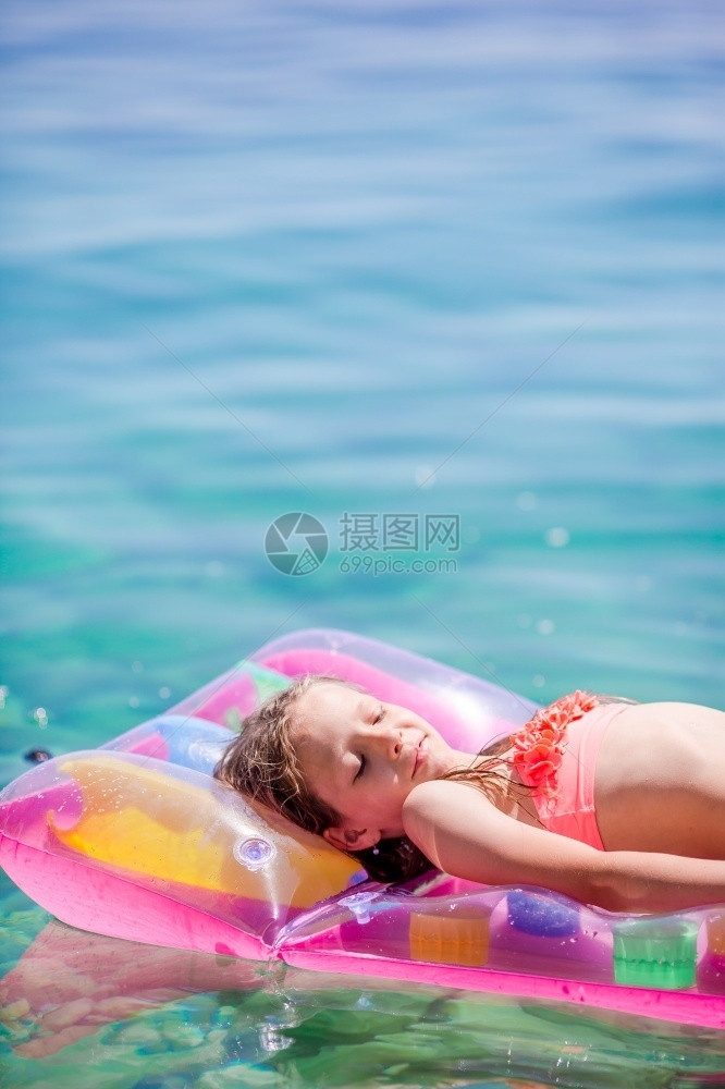 水中小女孩躺充气垫上图片