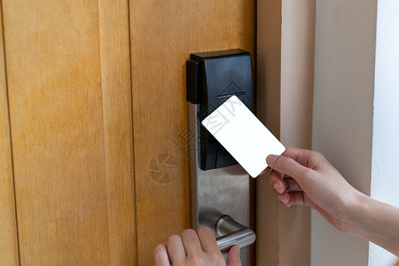 门出入控制手持白色模拟钥匙卡以锁和打开门数码锁的女子手使用权密码系统图片