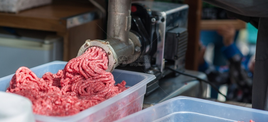 切割屠宰场新鲜肉机的托盘将放回机器里工业的图片