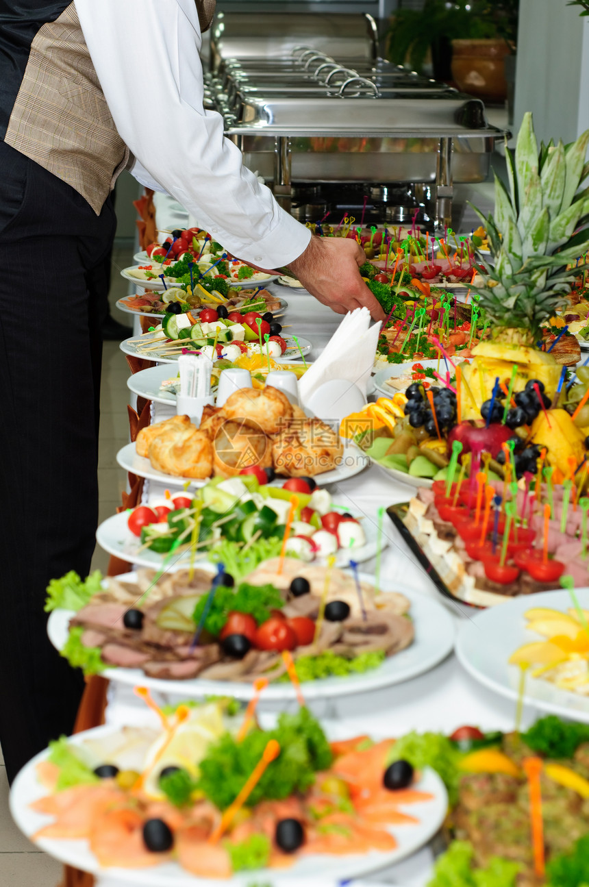 水果富有的宴席桌位盛满了美味的盘子餐桌银服务图片