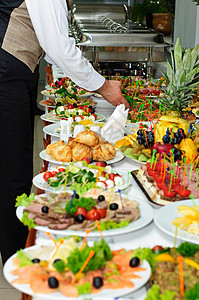 水果富有的宴席桌位盛满了美味的盘子餐桌银服务背景图片