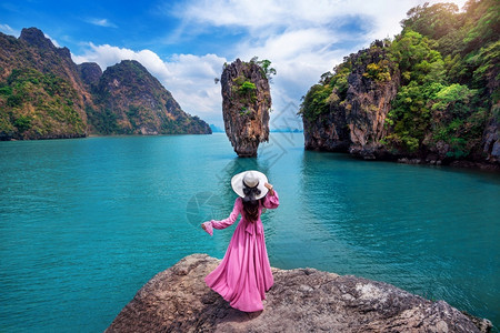 安达曼快乐的冒险站在泰国Phangnga的詹姆斯邦德岛岩石上的漂亮女孩背景
