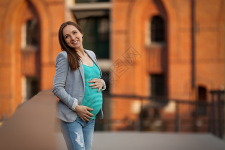 母亲微笑的孕妇肖像城市图片